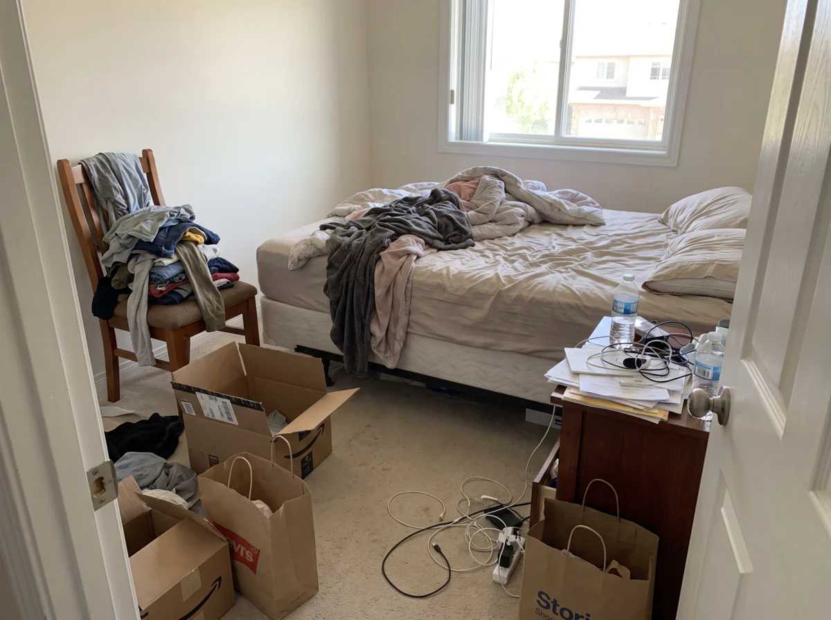 Before: cluttered bedroom with clothes, boxes and cables on the floor